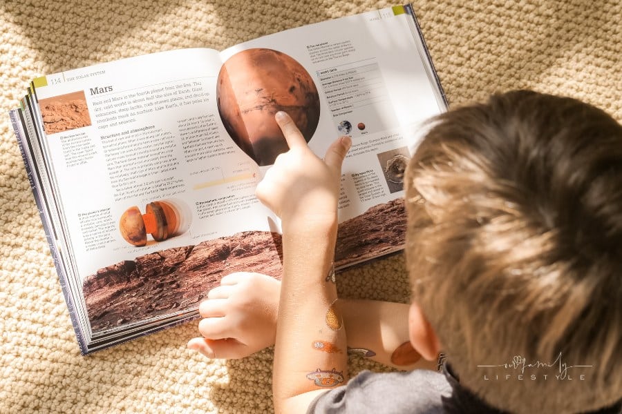 Boy reading a Book about planets