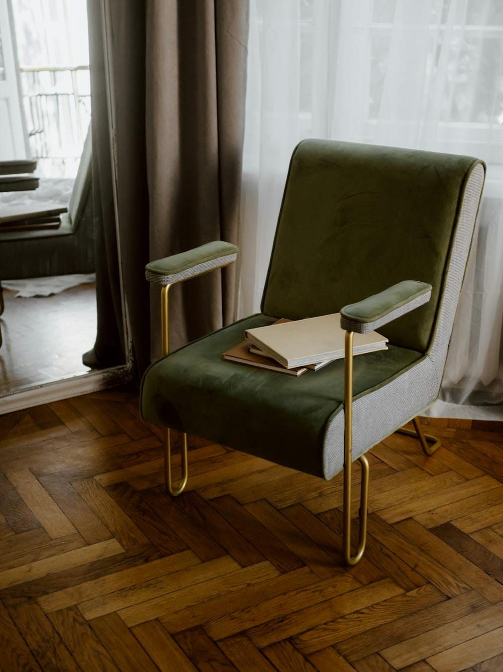 Stylish green armchair with gold legs in a contemporary apartment interior.