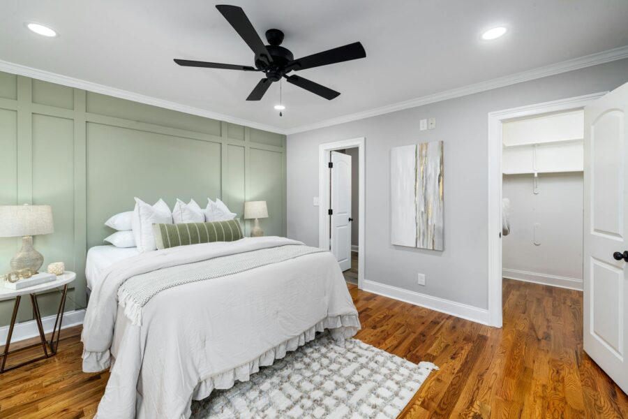 Stylish modern bedroom featuring elegant design with green accent wall and hardwood floors.