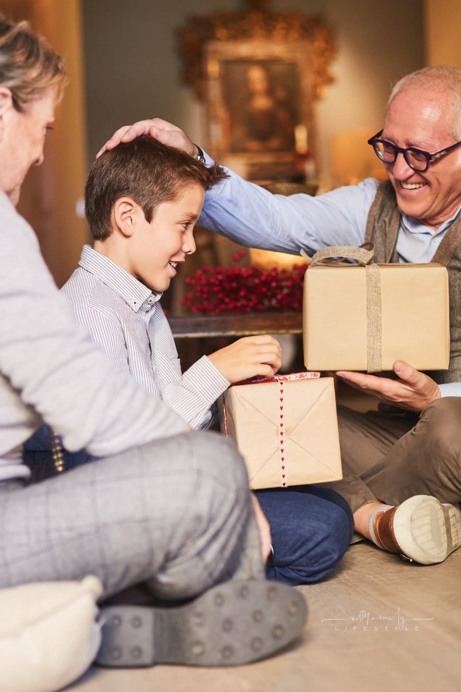 Grandparents and grandson unwrapping christmas gifts.