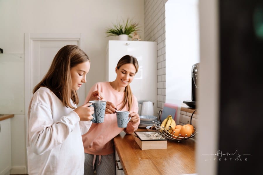 Mother and Daughter Talking while steeping and Drinking Tea in Kitchen