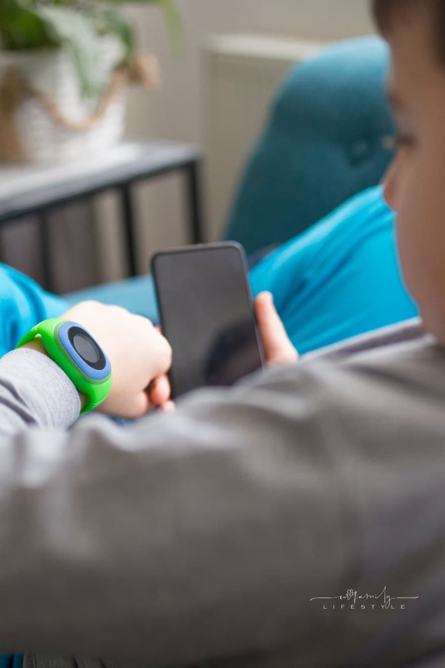 Boy Using Smart Watch and smartphone at home