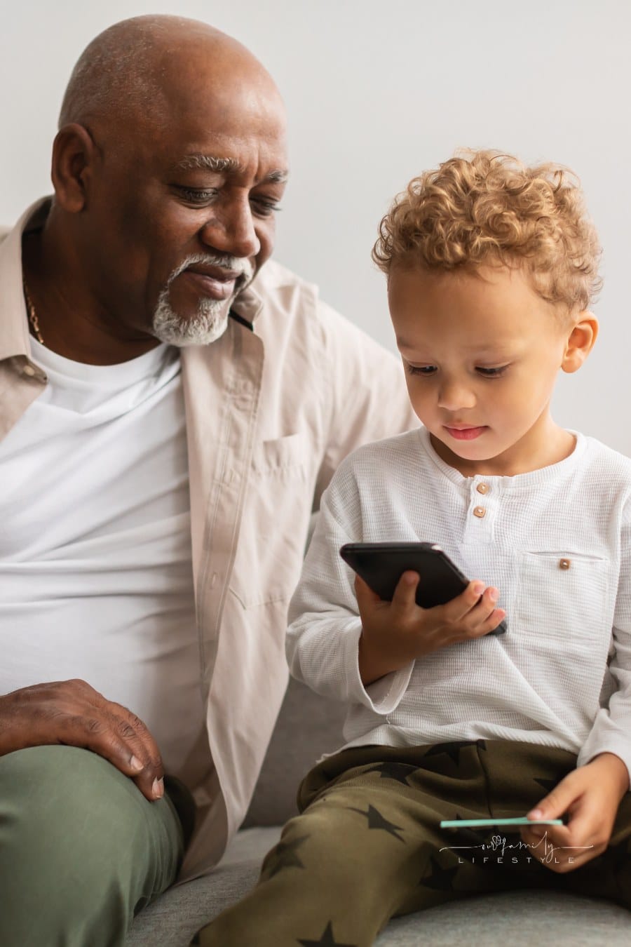 Grandpa Showing Smartphone to Grandson at Home