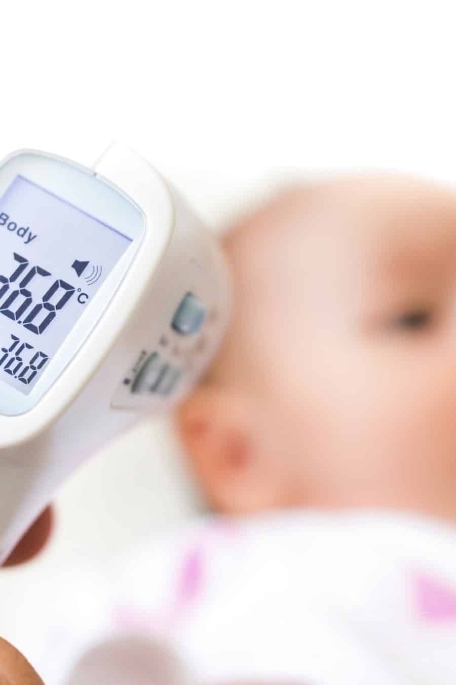 Measure baby's fever with digital fever meter. sick baby with high fever