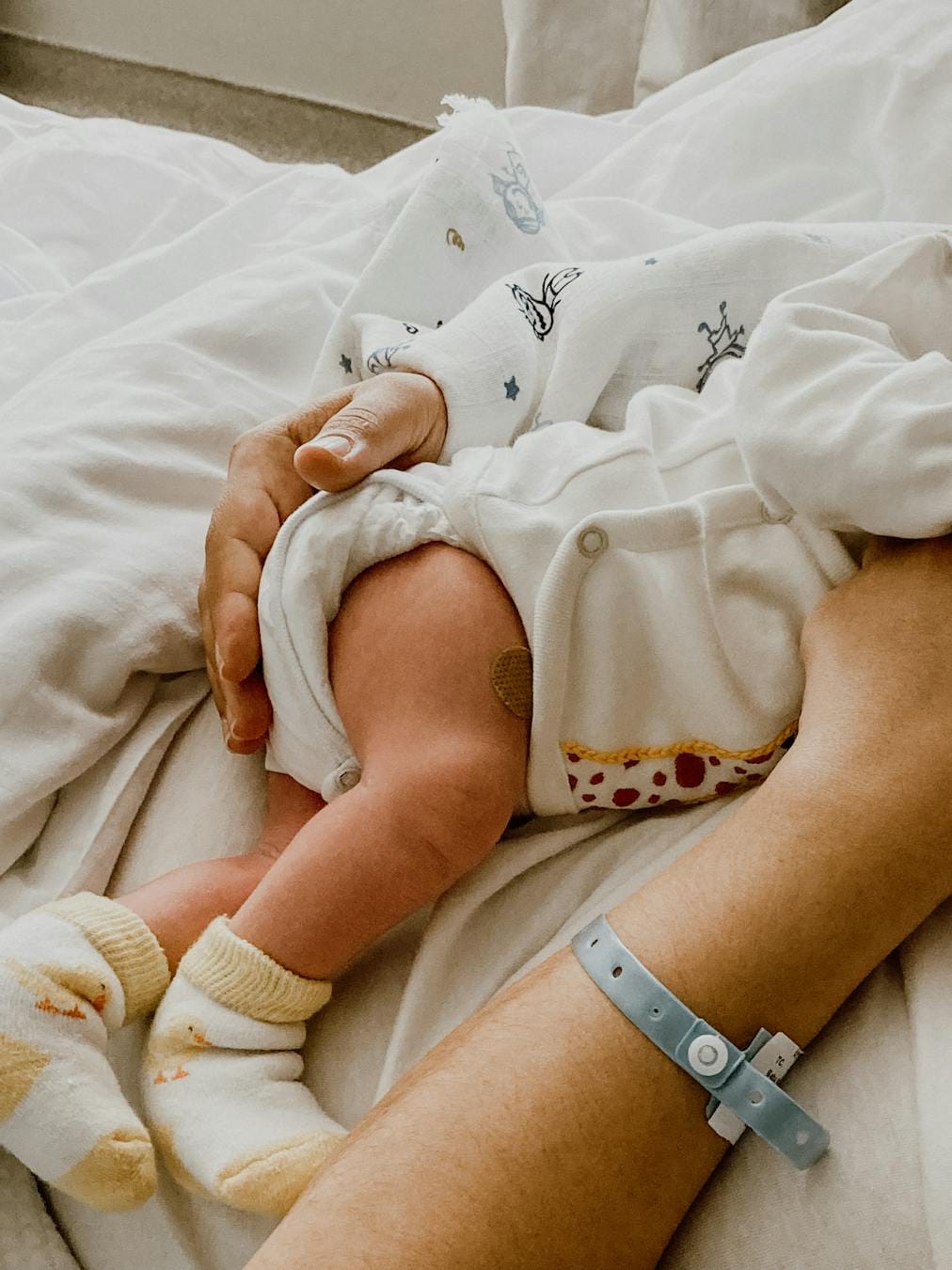 Tender moment captured between mother and newborn baby in a hospital setting.