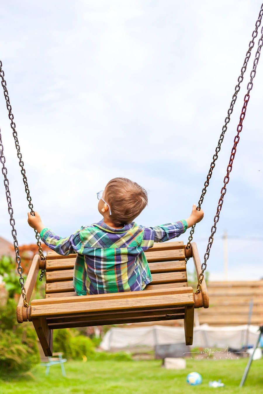 Child swinging on swing in the backyard