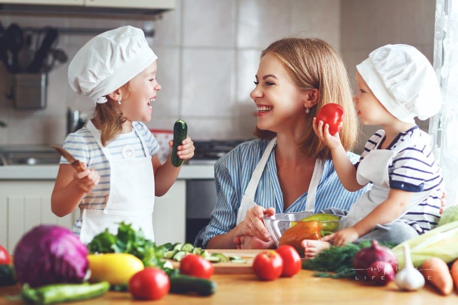 Healthy eating. Happy family mother and children prepares vegetable salad