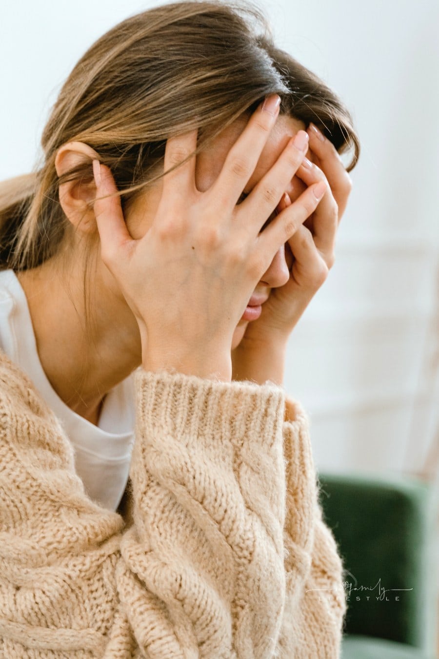 Woman Sitting with Hands Covering Her Face