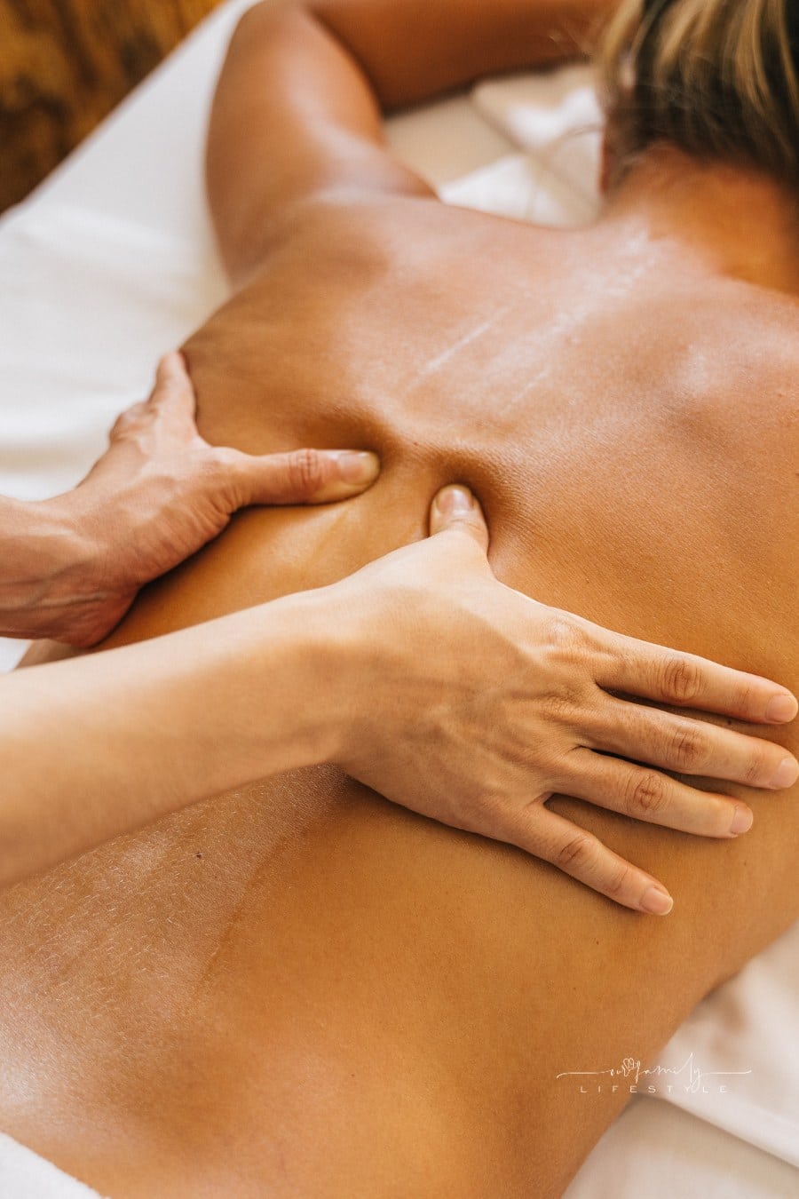 A Person Massaging a Client's Bare Back