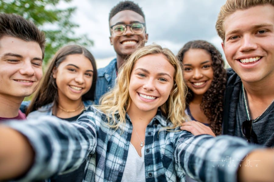 group of teens smiling at the camera selfie