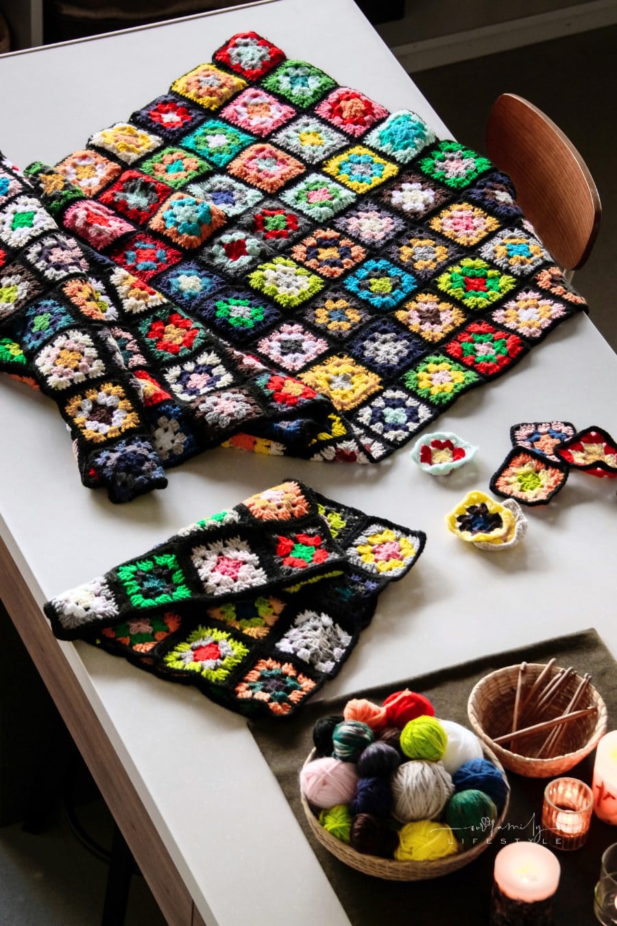 Granny squares,Yarn balls and crochet needles on table.