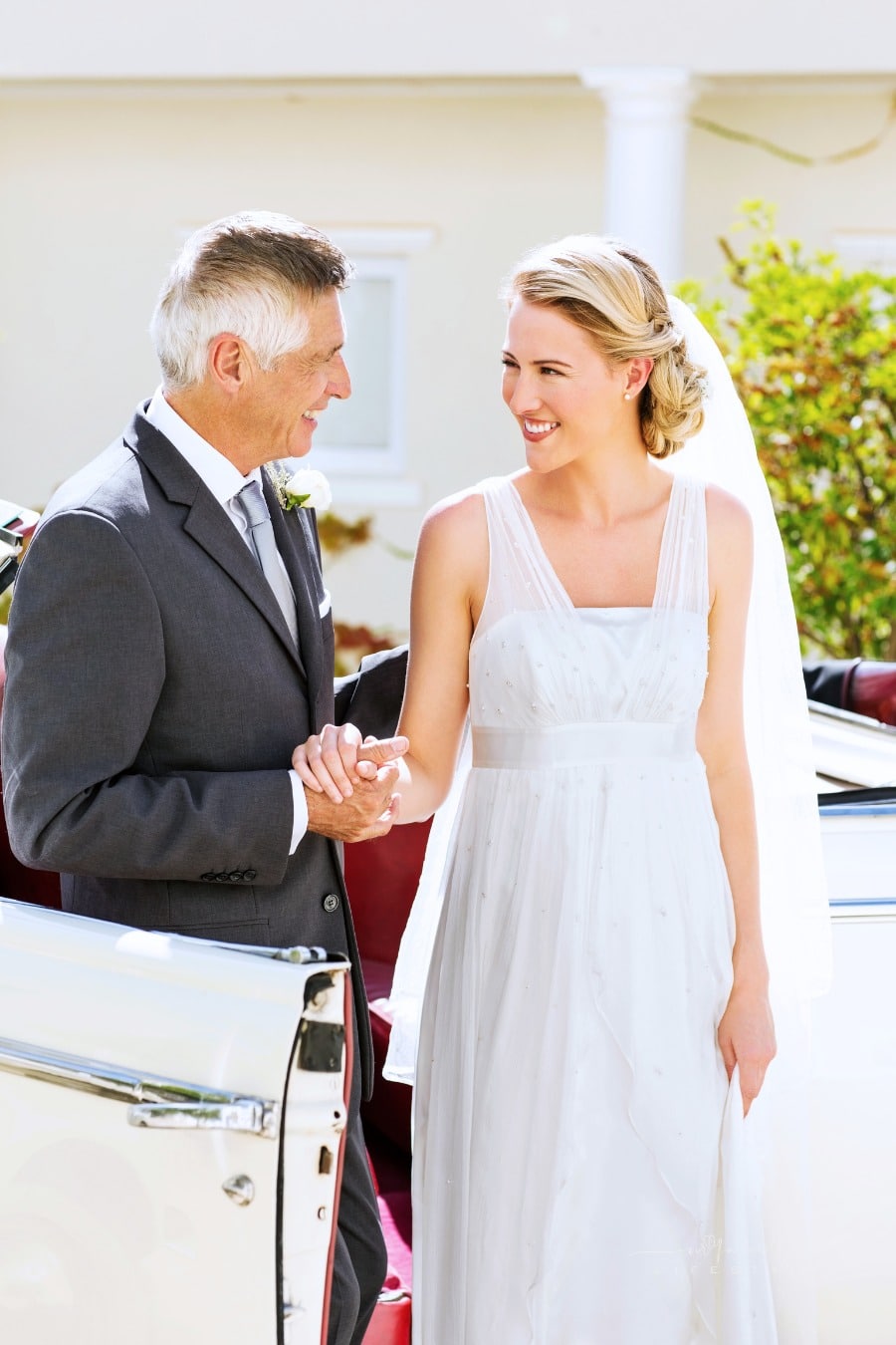 father helping daughter out of car at her wedding