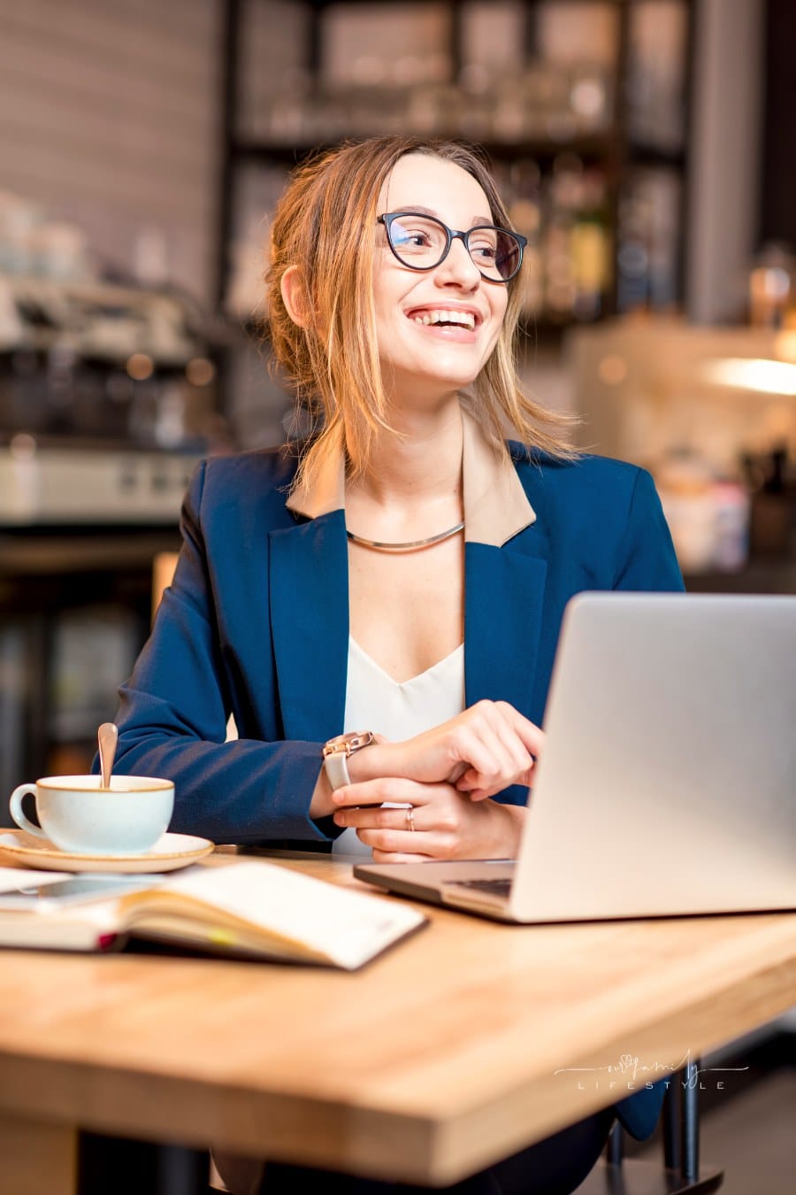young professional working on laptop at coffee shop