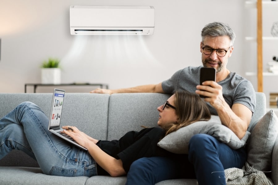 man and woman enjoying air conditioning inside home