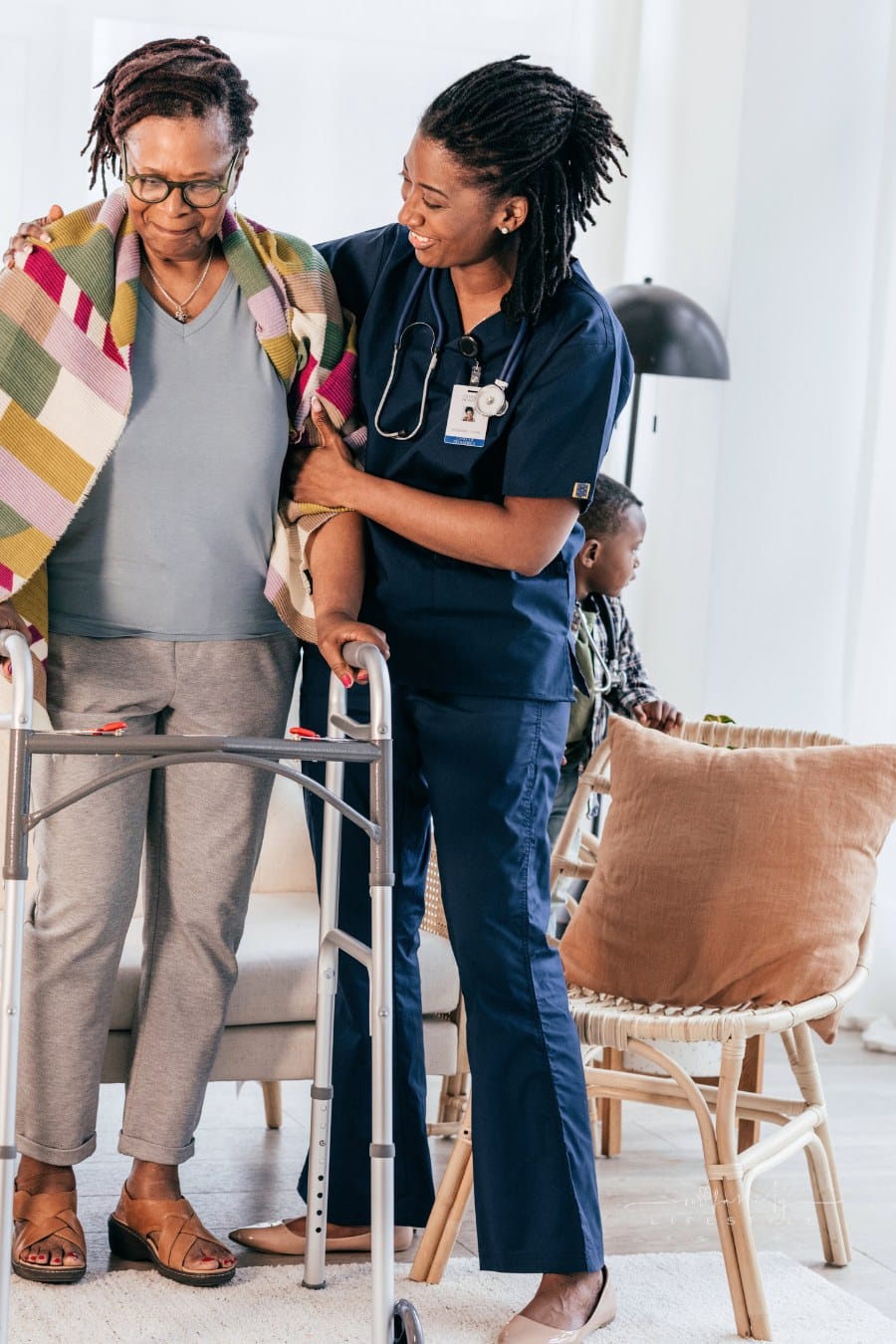 nurse helping elderly woman with a walker at an assisted living community