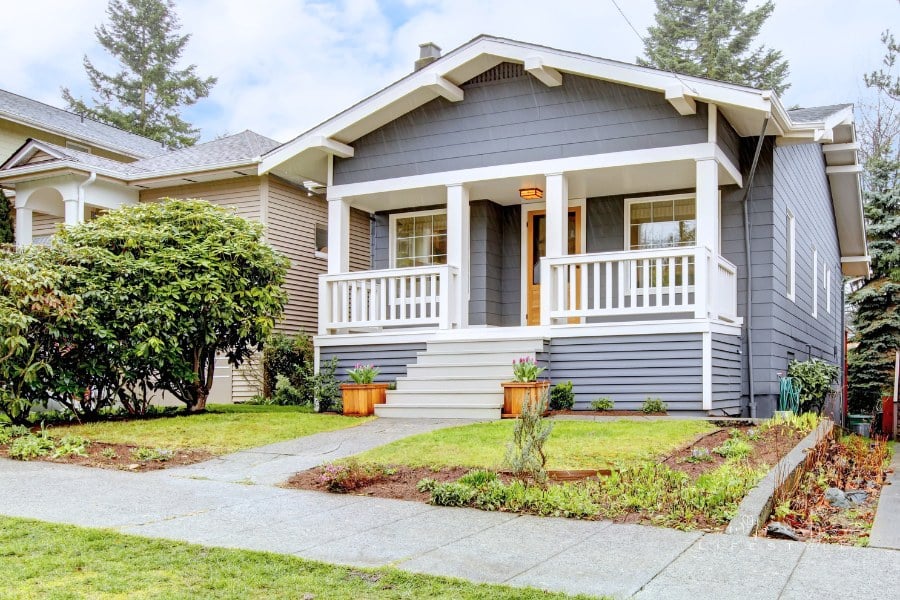 Grey craftsman style house with white porch.