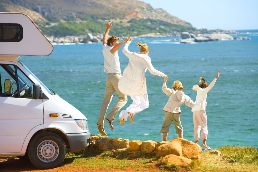 family jumping with joy on rv trip