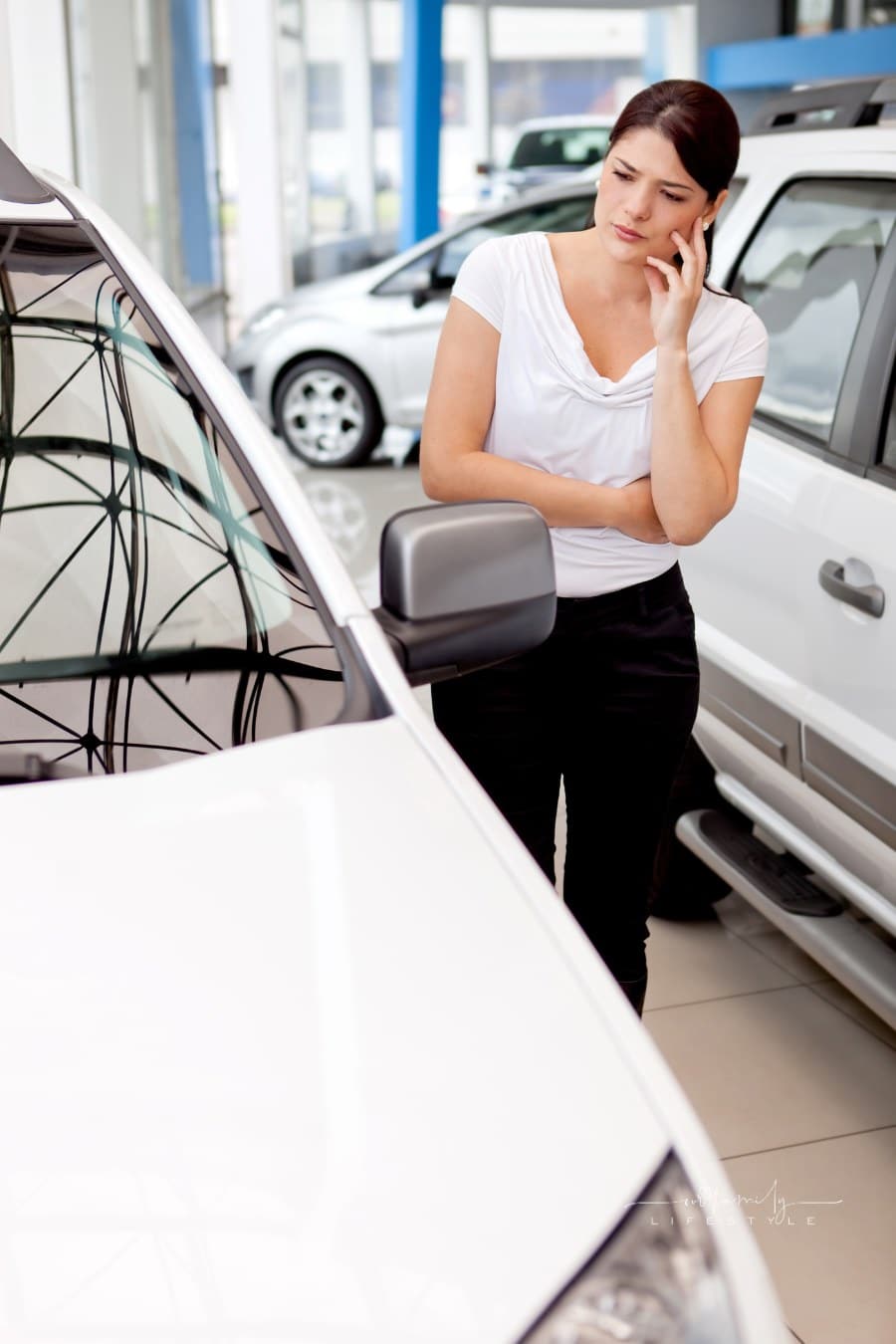woman considering buying a car as she examines it