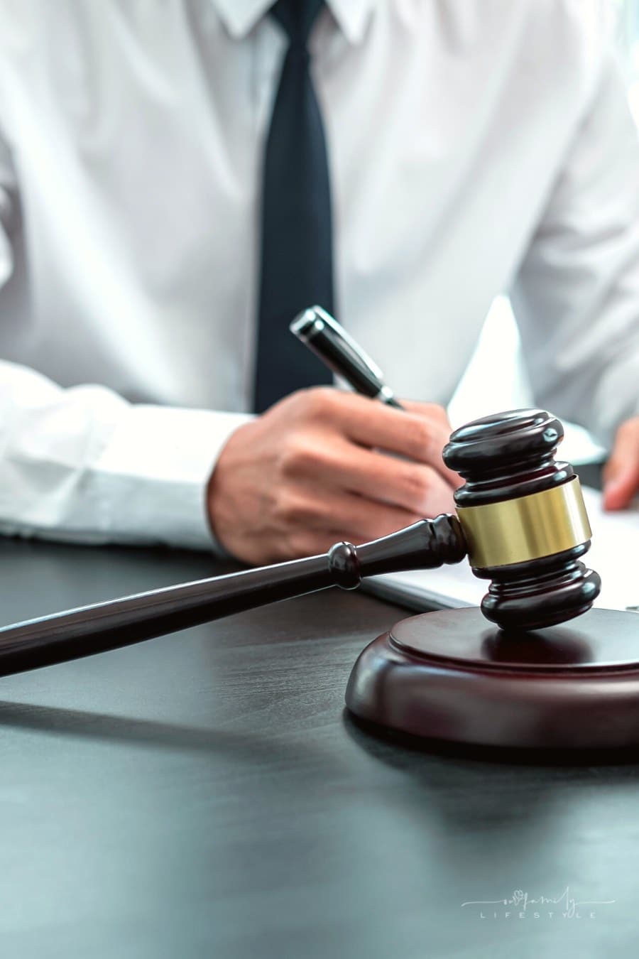 lawyer taking notes in background with gavel in forefront