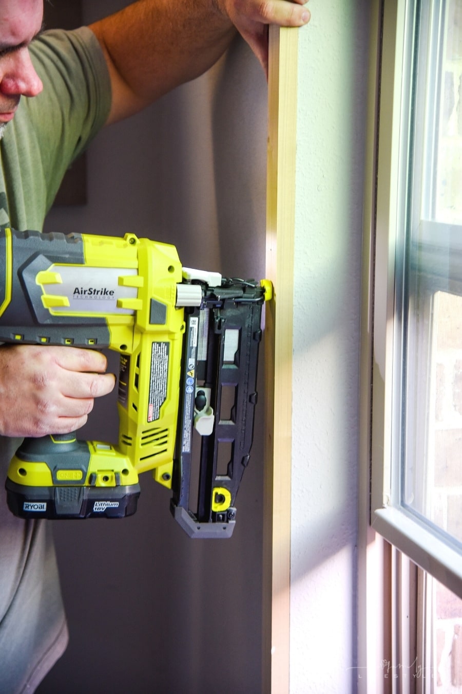 using nail gun to add trim around windows