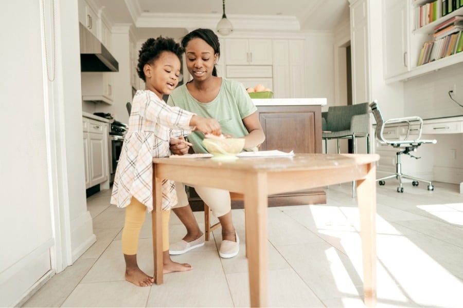 mom and toddler daughter spending time together in kitchen