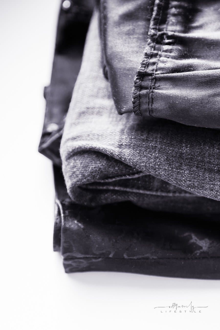 dark grey and black clothes folded and stacked