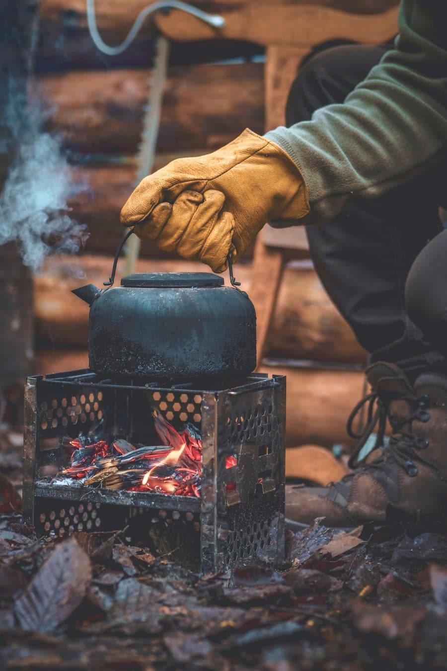Hand in Glove Holding Kettle over Fire