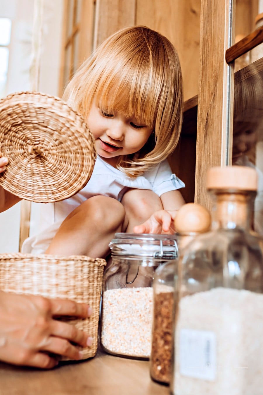 little girl healping mom with ingredients in kitchen
