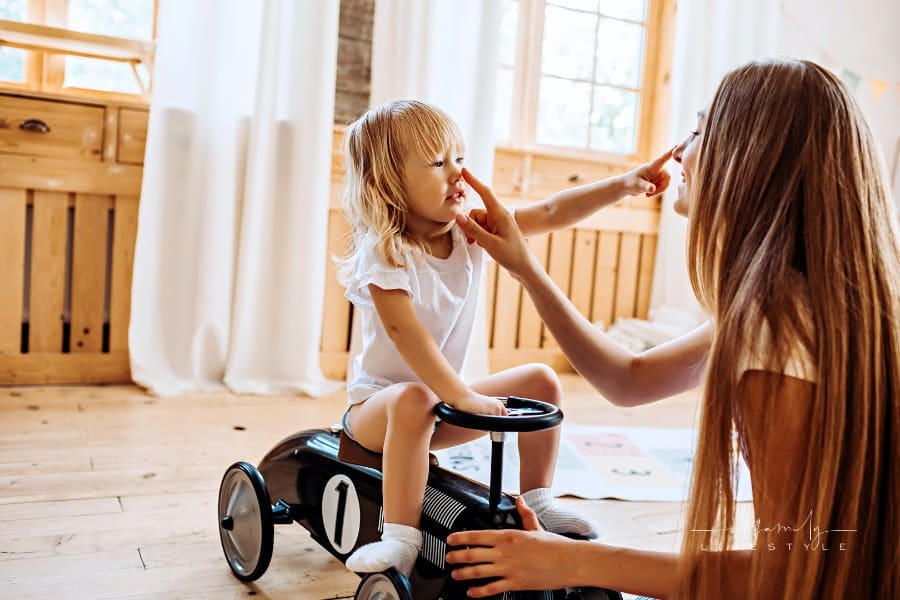 Young mother playing with little daughter having fun and laughing at home. Family Lifestyle Image.