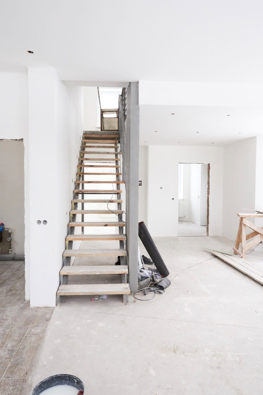 house interior renovation with bare stairs, floors, and walls