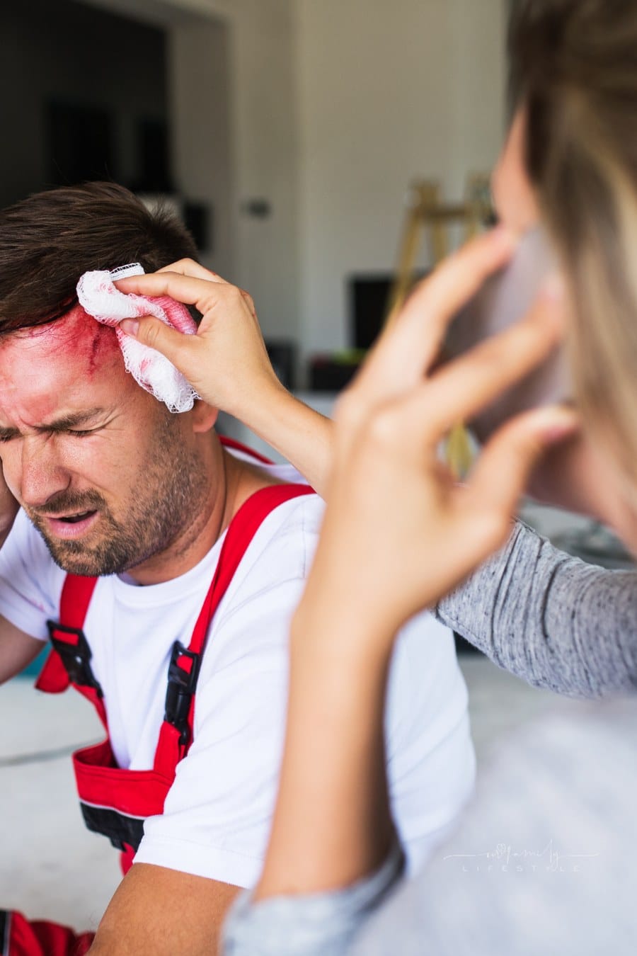 A Woman with Smartphone Helping Man Worker after an Accident at the Construction Site.