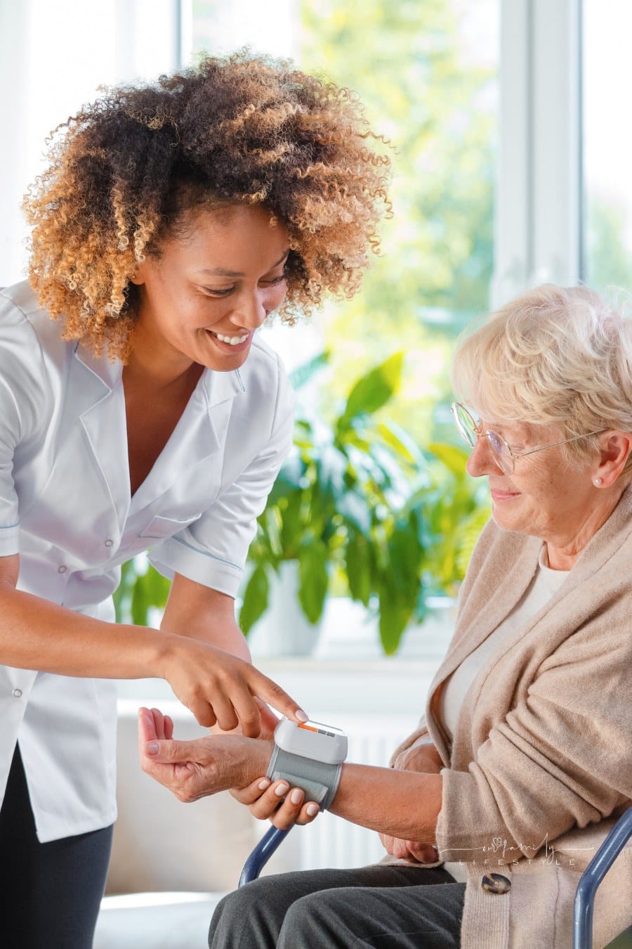 home care giver taking blood pressure of elderly patient