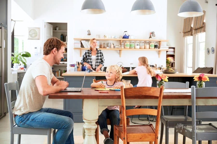 Dad and Son at Kitchen Table with mother and daughter in the background