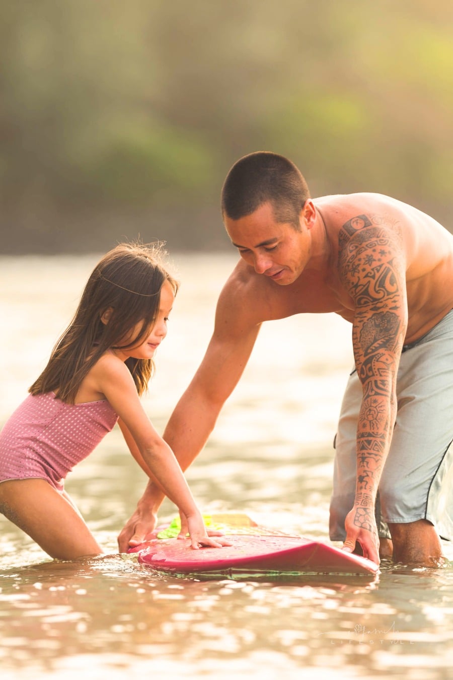 dad and daughter prepping boogie board in Hawaii