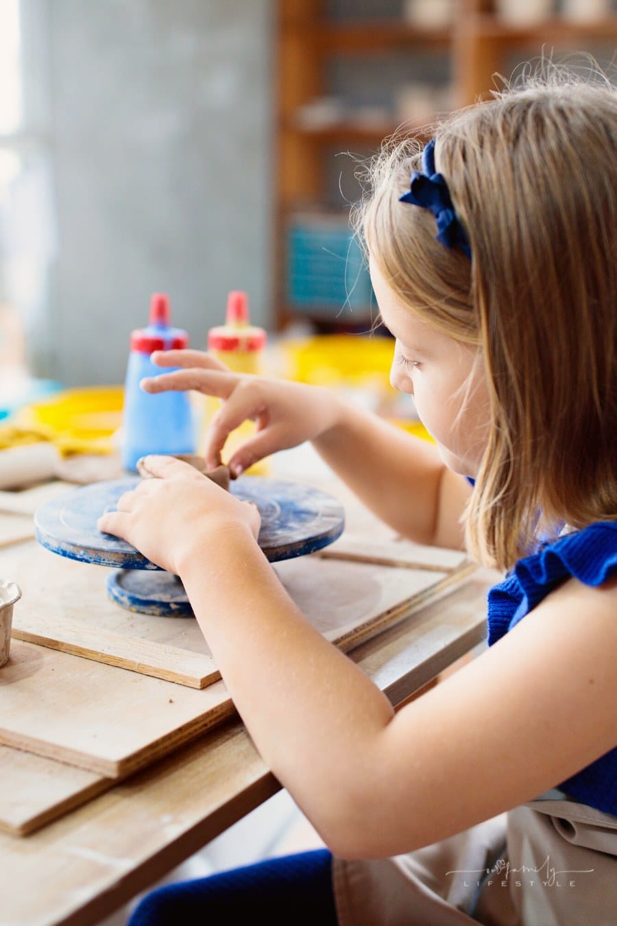 child working with pottery wheel