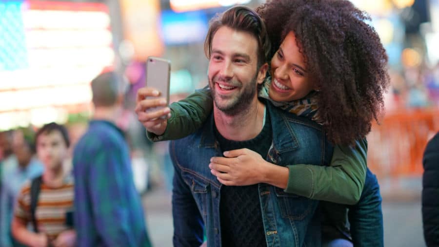 young couple taking a selfie in Time Square
