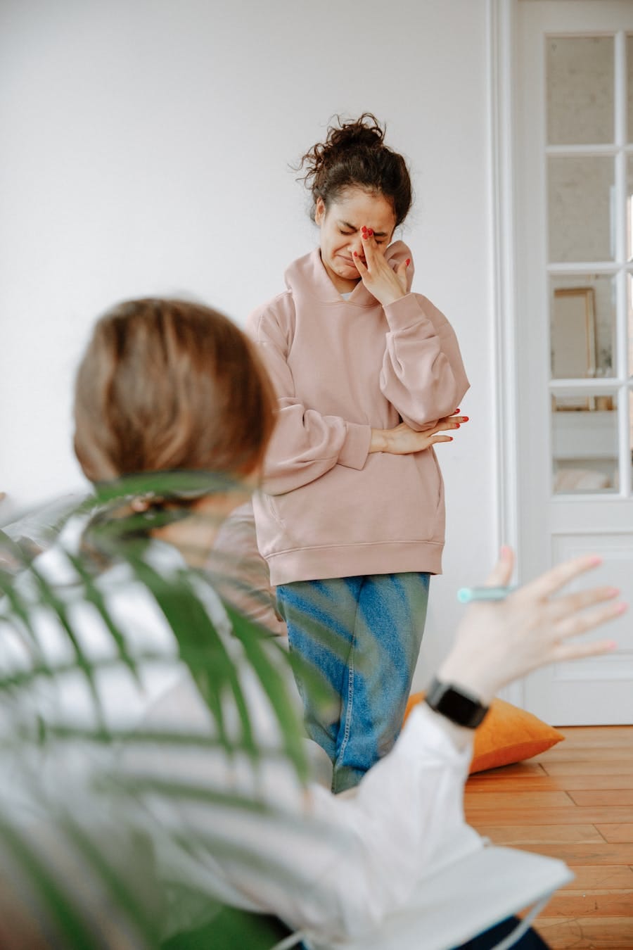 Young woman in therapy session expressing emotions indoors.