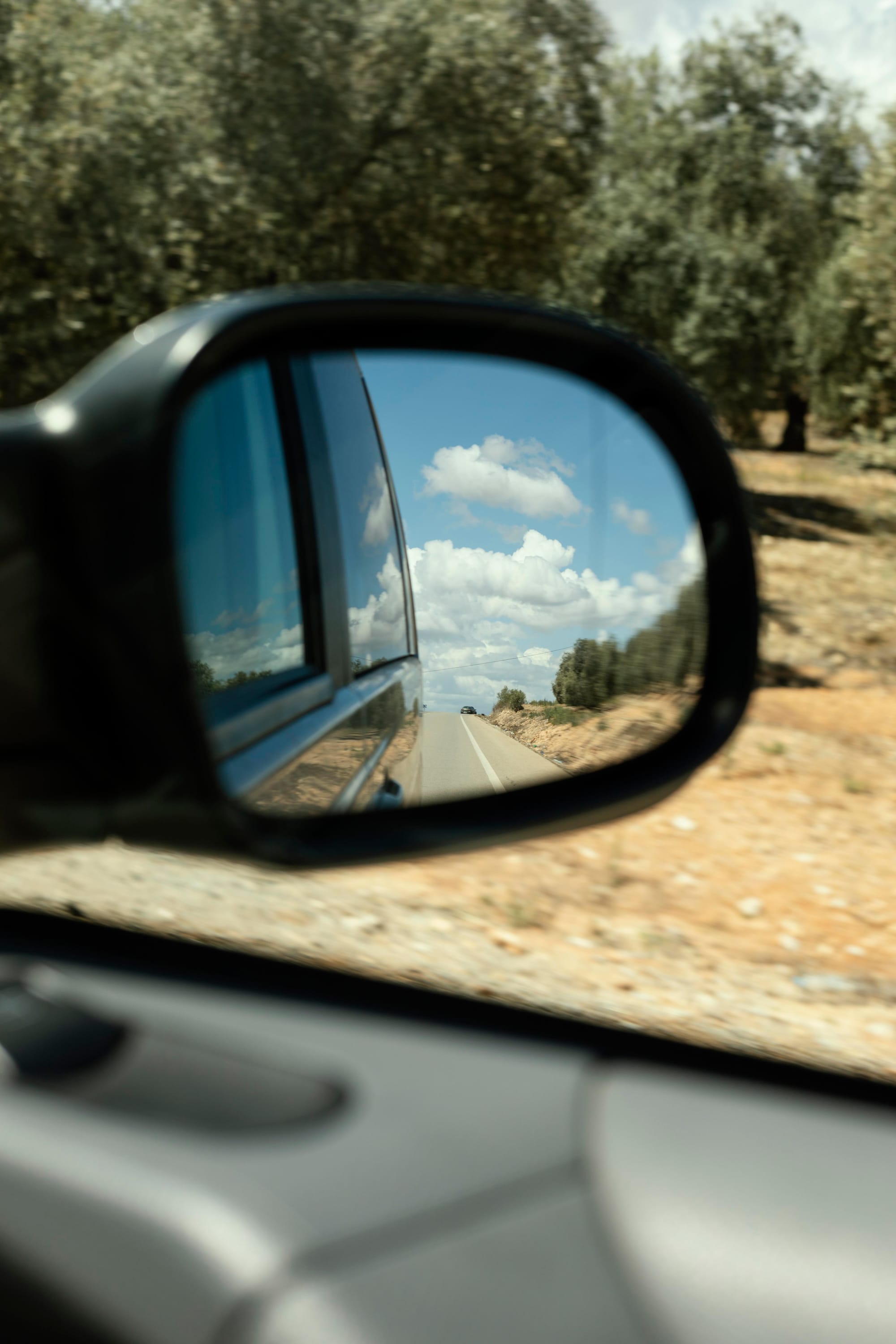 close up of car side mirror with landscape behind car