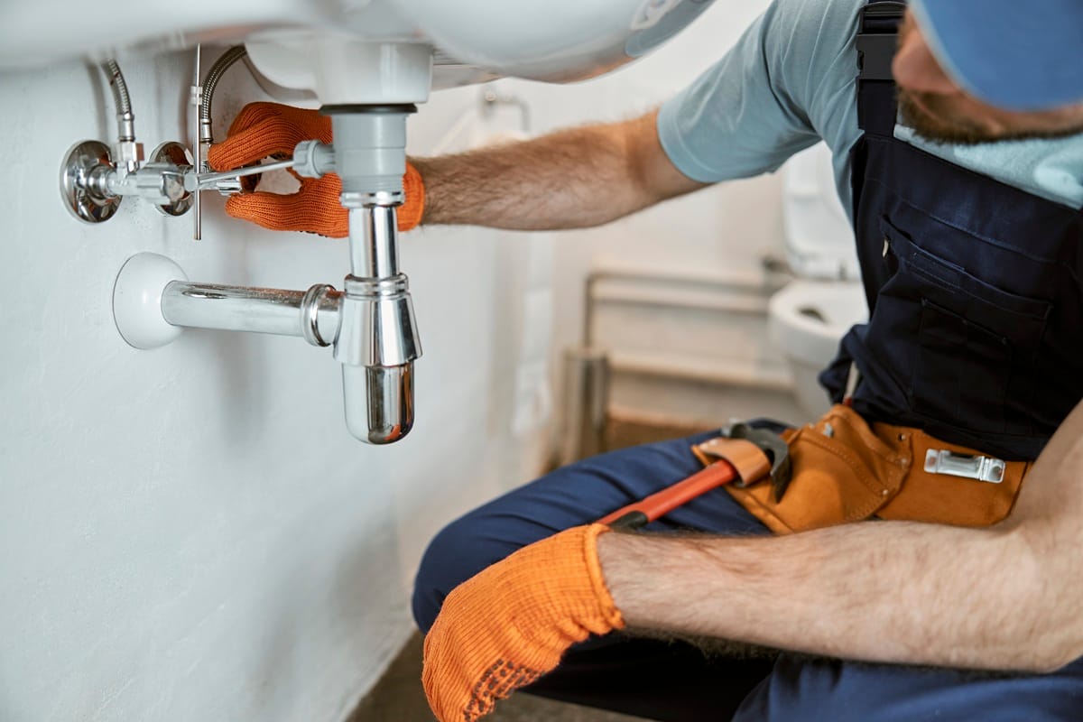 male-plumber-hands-repairing-pipe-sink