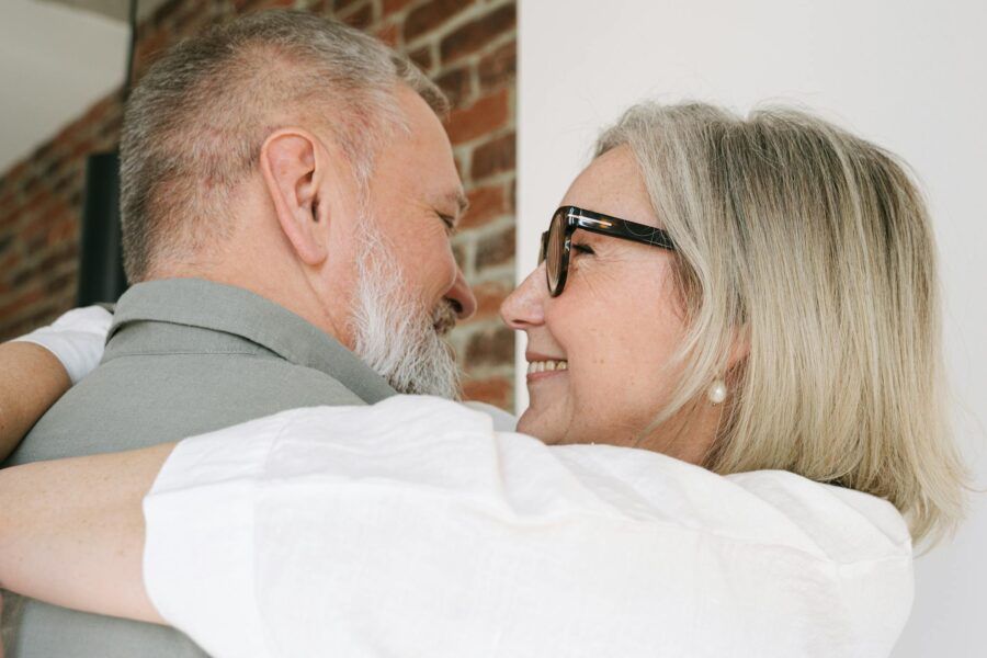 A happy senior couple embracing with love and closeness, captured in a home setting.