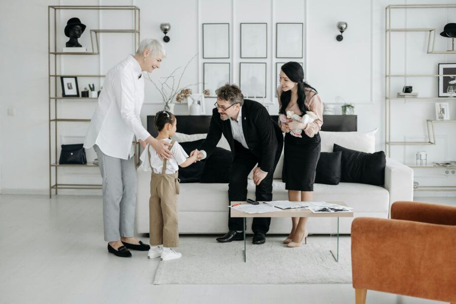 A welcoming family scene involving adults and children indoors, showcasing connection and warmth.