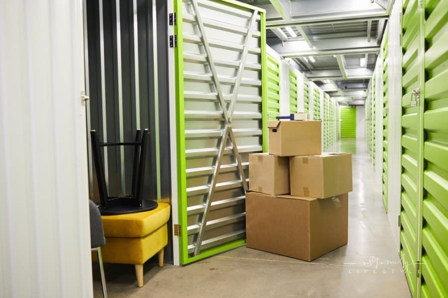 Background image of cardboard boxes stacked by open door of self storage unit