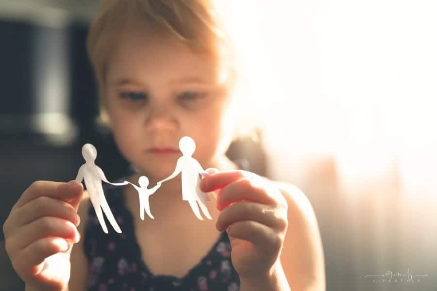 sad little girl with paper family