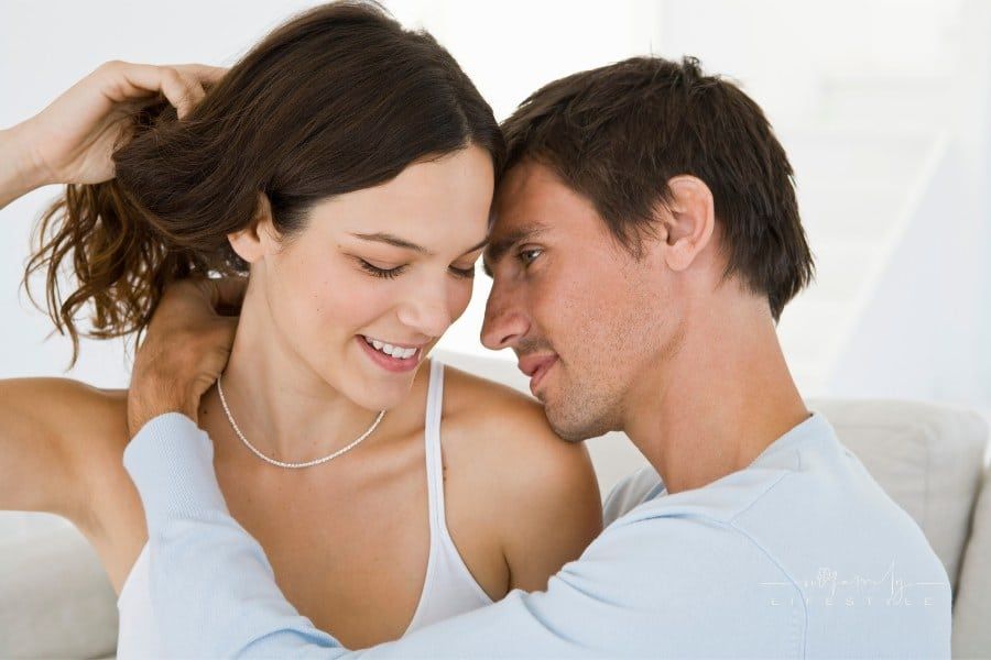 Man putting necklace on woman