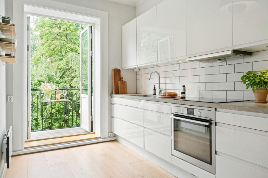 Clean, modern kitchen with white cabinets and open balcony view for fresh inspiration.