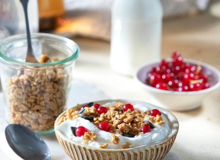 Delicious yogurt bowl topped with granola and red currants, perfect for a healthy breakfast.