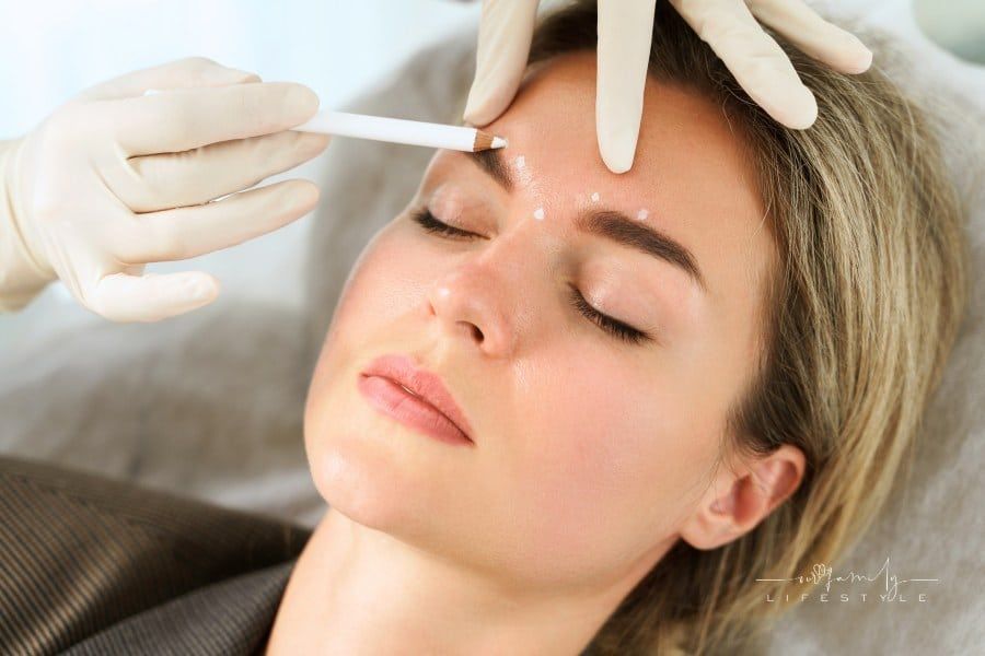 Female client during facial filler injections in aesthetic medical clinic