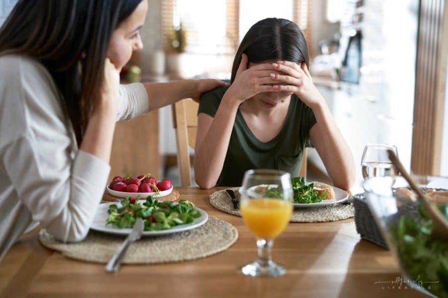 mom comforting teenage daughter with eating disorder