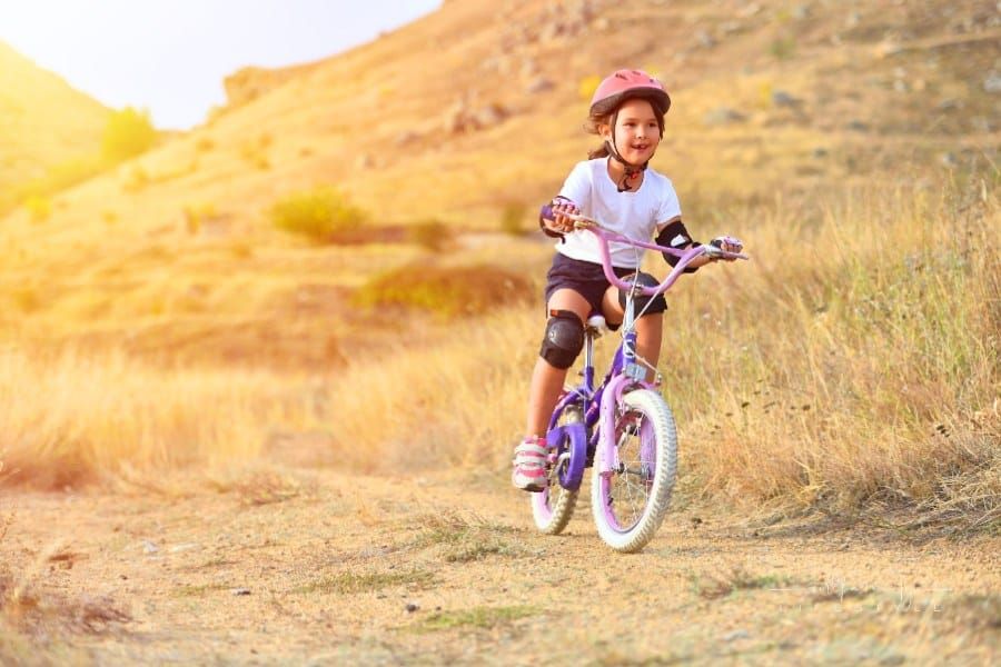 Happy Kid Having Fun in Autumn Park with a Bicycle with full bike gear on