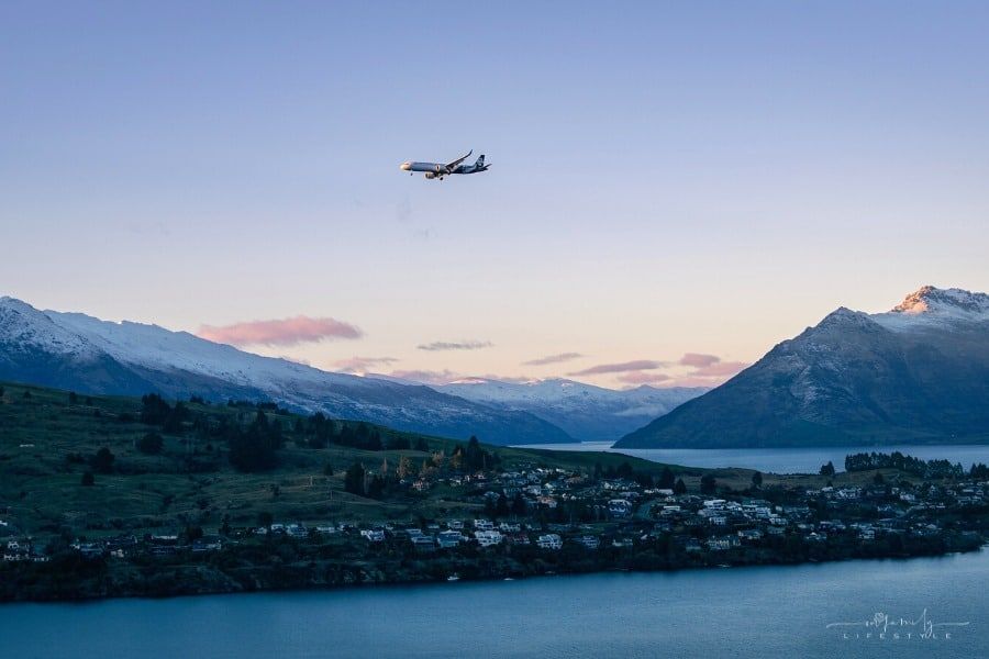Air NZ plane flying over Lake Wakatipu in Queenstown, South Island, during sunset